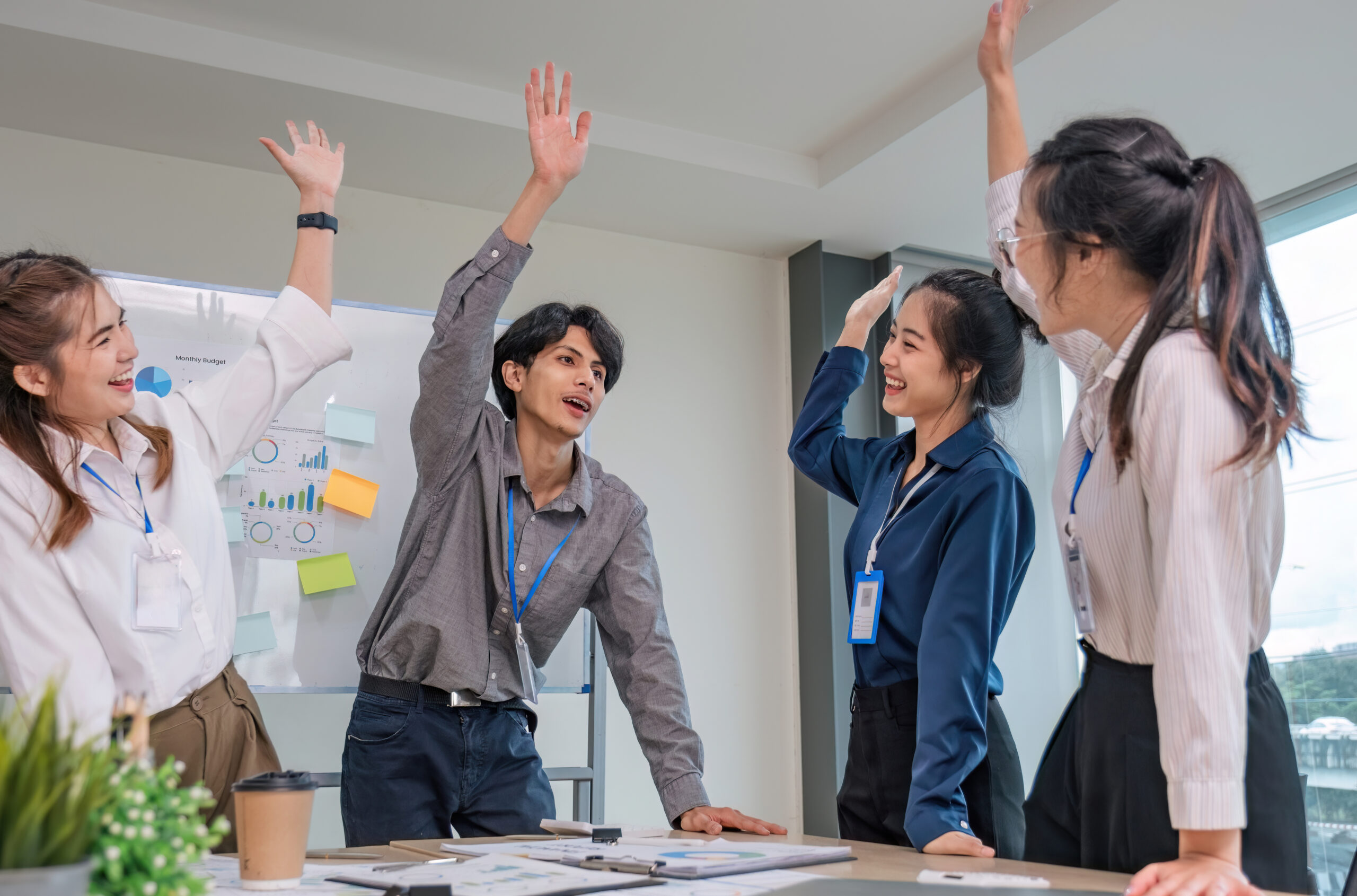 Four cheerful workers celebrate promotion and change in their job titles.